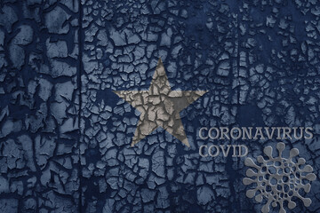 flag of somalia on a old metal rusty cracked wall with text coronavirus, covid, and virus picture.