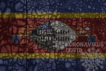 flag of swaziland on a old metal rusty cracked wall with text coronavirus, covid, and virus picture.