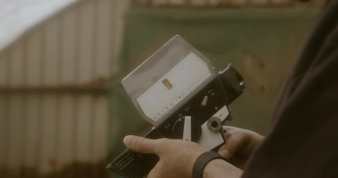 Slow motion shot of a man using a vintage camera taking pictures in a Plant nursery