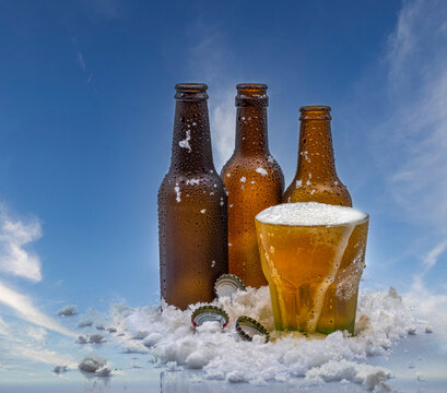 Three empty beer bottles and a full glass of beer