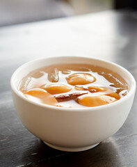 Close-up A bowl of Sala seedless in syrup with ice on the wood table.