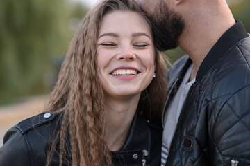 Young, stylish and attractive man and woman in the park in autumn. Couple in casual style, happy husband and wife.