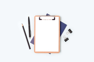 Clipboard with blank paper sheet mockup and stationery on a blue background. Workspace for...