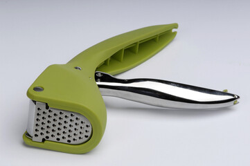 green garlic squeezer on a white background