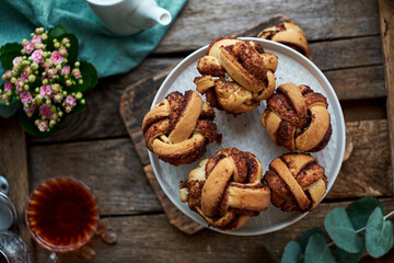 Cinnamon rolls, round yeast buns. Top view, wooden background.