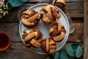 Cinnamon rolls, round yeast buns. Top view, wooden background.