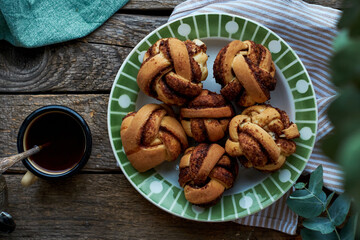 Cinnamon rolls, round yeast buns. Top view, wooden background.