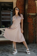 young woman in beige dress on the street