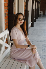 young woman in beige dress on the street