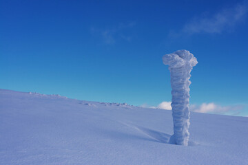 Snow covered signpost on the mountainside. Winter landscape with signpost.