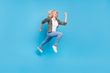 Fototapeta na wymiar Full length body size photo happy woman jumping up running fast isolated pastel blue color background