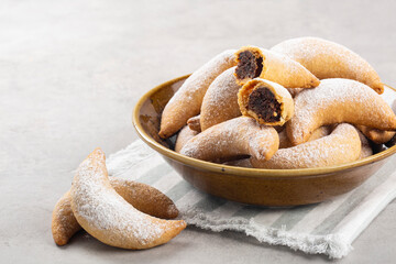 Homemade crescents stuffed with walnuts and choccolate. Light grey background. Close up. Copy space.