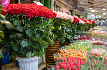 Flower shop with bouquets of various fresh tulips and roses for sale. Street flower market.