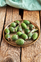 Feijoa on a plate on a wooden background