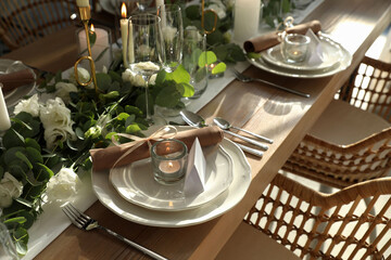 Elegant table setting with beautiful floral decor and burning candle