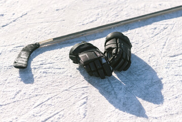 The gloves and hockey stick lay on the snow
