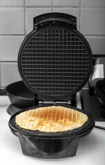 The waffles are baked in an electric waffle iron. Homemade baking. Photo