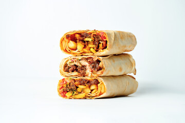 Shawarma stacked one on top of the other with meat and vegetable filling. A stack of shawarma on a white background. Selective focus