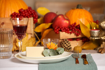 Beautiful autumn place setting with blank card and decor on table
