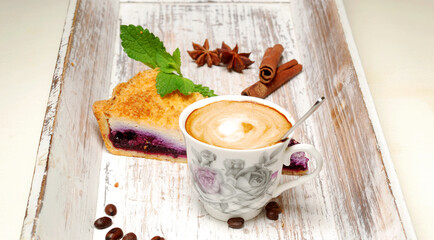 Vintage wooden tray with porcelain teacup and blueberry pie