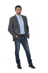 Fototapeta premium front view of a man with blazer and jeans with hands in pockets on white background