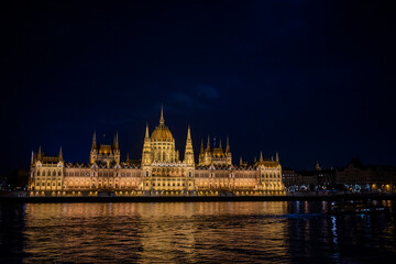 Fototapeta premium view of the facade of the building of the parliament of budapest hungary at sunset at night with lights on the banks of the Danube river