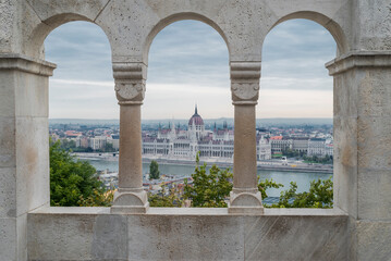 view of the facade of the building of the parliament of budapest hungary on the riback bastion through the arch