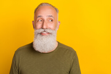 Photo of funky elder white beard man look empty space wear green sweater isolated on yellow color background