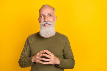 Photo of positive smart sly grandpa hold fingers look empty space wear green shirt isolated yellow...