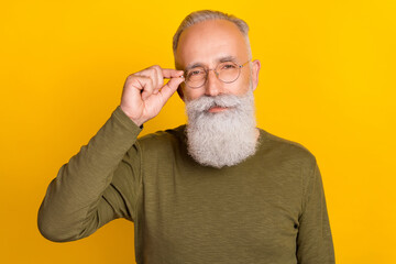 Photo of smart aged white beard man touch eyewear wear green sweater isolated on yellow color background