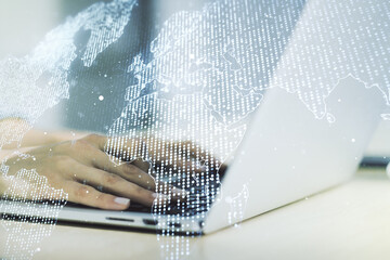 Abstract creative digital world map and hands typing on laptop on background, globalization...