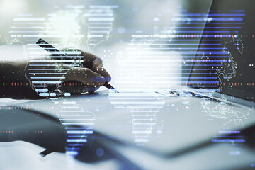 Abstract creative world map and hand writing in notebook on background with laptop, international trading concept. Multiexposure