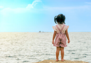 Naklejka premium An image child looking to turn around the sea in holiday the outdoor vacation day ocean with blue sky for the background as motion happiness.