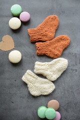 Small woolen handmade baby socks, on gray background
