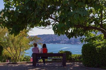  Friends sitting on the wooden bench and looking at the sea Istanbul, turkey