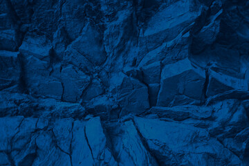 Blue rock texture. Toned mountain surface. Close-up. Navy blue grunge background for design. Crumbled layers.