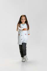 Full-length portrait of cute beautiful little girl, child in image of doctor wearing white lab coat...