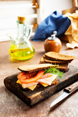 Sandwich with tasty ham on wooden board
