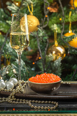 Red caviar in a a ceramic bowl, silver beads and pearls on a silver tray. Christmas and New Year...
