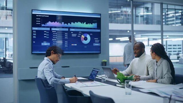 Multi-Ethnic Office Conference Room Meeting: Team of Three Creative Entrepreneurs Talk, Discuss Growth Strategy. Stylish Young Businesspeople work on Digital e-Commerce Startup, Uses TV Screen.