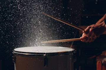 Fotobehang Close up drum sticks drumming hit beat rhythm on drum surface with splash water drops in air © primipil