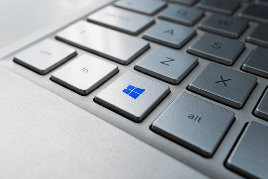 button with the logo Windows on the grey keyboard of a modern laptop.