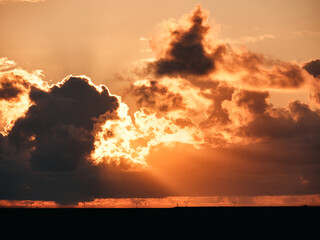 Cloudy sunset sky over field