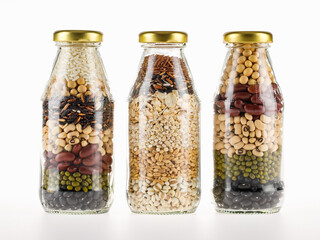 Clear glass bottles contain clean organic cereal grains, seeds, dry crops, beans, rice as raw...