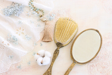 Fototapeta na wymiar Background of white delicate lace fabric, neckless and vintage hand mirror