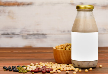 Healthy milk nourishment drink from organic beans extract in glass cup and bottle as advertising beverage product for natural vegan breakfast