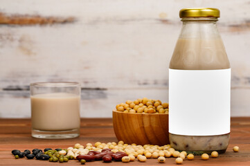 Healthy milk nourishment drink from organic beans extract in glass cup and bottle as advertising beverage product for natural vegan breakfast