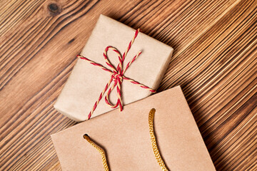 Christmas composition of gift boxes in the paper bag on wooden background