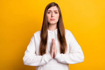 Portrait of attractive hopeful girl wearing cozy pullover asking favor isolated over bright yellow...