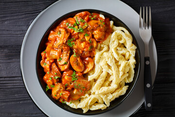 spaetzle with mushroom gravy in a black bowl